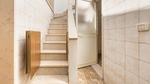 A staircase with a wooden handrail, a door with frosted glass, and tiled walls. - 2907 Casa la Terrazza by Barbarhouse (Manduria)
