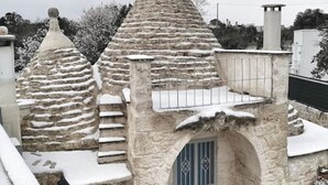 Un bâtiment en pierre doté d’un toit en forme de flèche et d’un petit balcon.