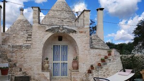 Il s’agit d’un bâtiment en pierre, doté d’un toit conique, d’une entrée centrale en arc de cercle et d’une cheminée. On y trouve des plantes en pot et du mobilier d’extérieur.