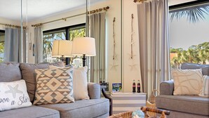 Ein modernes Wohnzimmer mit grauen Sofas, gemusterten Kissen und einem Korbwäsche mit Dekoration.