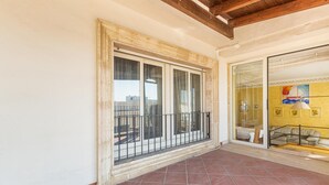 A balcony with a tiled floor, a glass door leading to a room with a sofa and a lamp, and a window with a metal railing. - 2795 Casa Palma by Barbarhouse (Maruggio)