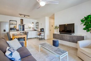 Una sala de estar moderna con un sofá, una mesa de centro y un televisor.