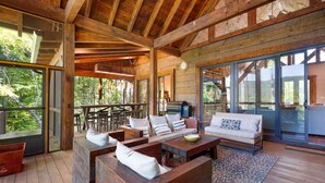 A spacious wooden deck with a sofa, coffee table, and seating area. - Copperline Lodge - located in Blue Ridge, GA (Epworth)