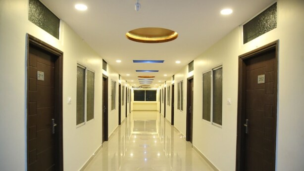 A long, well-lit hallway with doors numbered 201 and 202, leading to individual rooms. - Hotel Pavan Mansion (Raichur)