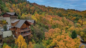 Eine Holzhütte mit Balkon, umgeben von Herbstlaub.
