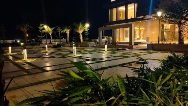 Un hotel moderno con un amplio espacio exterior que cuenta con un patio iluminado y una piscina.