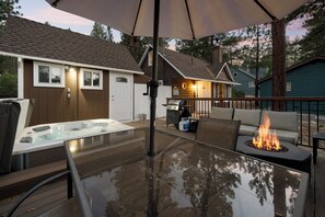 Une terrasse extérieure dotée d’un jacuzzi, d’un foyer et d’un espace salon abrité.