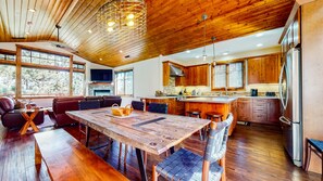 Une cuisine spacieuse avec des meubles en bois, un grand îlot central et une cheminée en pierre.