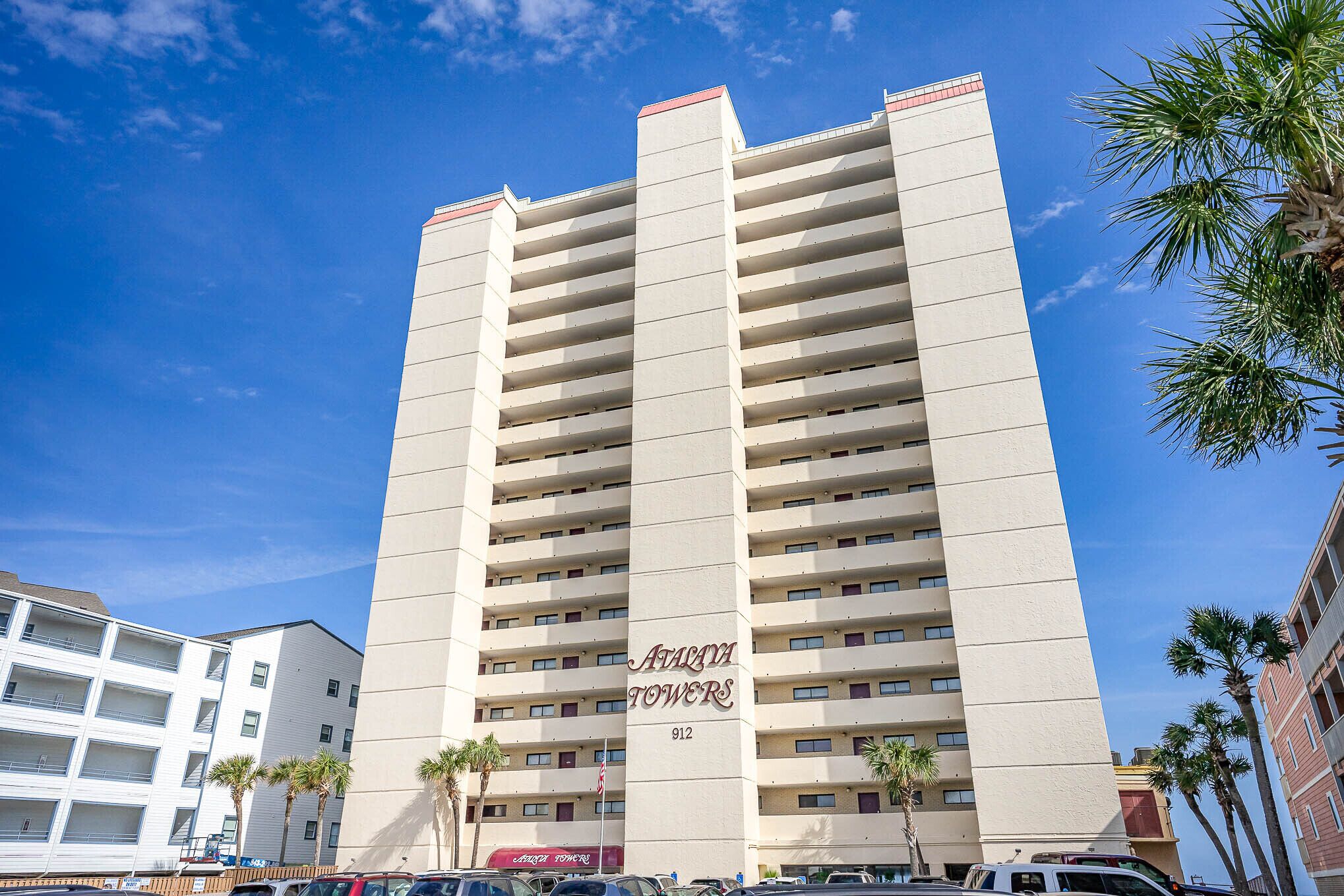 Un rascacielos con un letrero llamativo que dice 'Atalaya Towers 912'.
