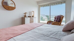 Une chambre à coucher avec un lit, une commode, un miroir et une chaise.