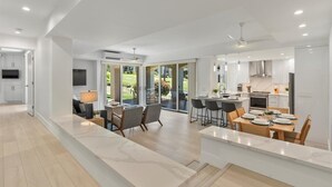 Una cocina moderna con comedor, ventanas amplias y vistas al exterior.