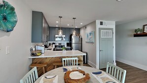 A modern kitchen with a central island, stainless steel appliances, and pendant lighting. - Luxe Gulf Front Condo, Stunning Views. Community Pool (Santa Rosa Beach)