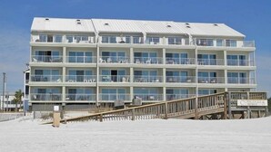 A multi-story hotel with balconies, a wooden deck, and a sign indicating it is a resort. - Luxe Gulf Front Condo, Stunning Views. Community Pool (Santa Rosa Beach)