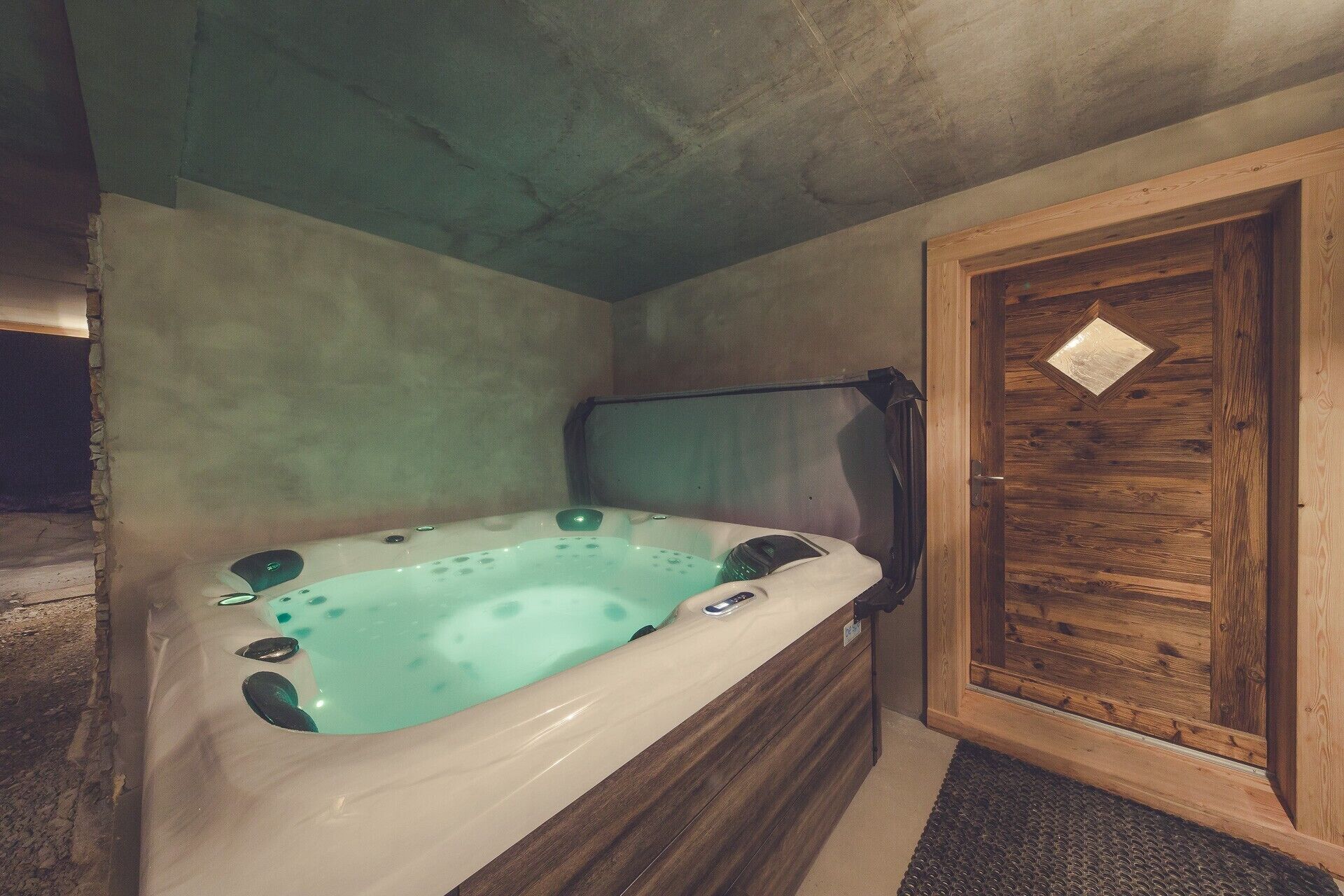 Un baño con bañera, puerta de madera y un perchero para toallas.