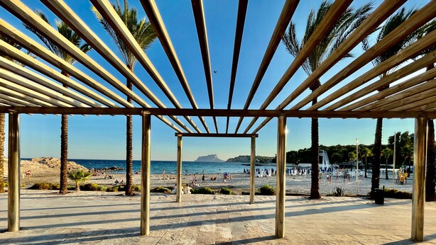En pavillon ved stranden med frit udsyn til både strand og hav.