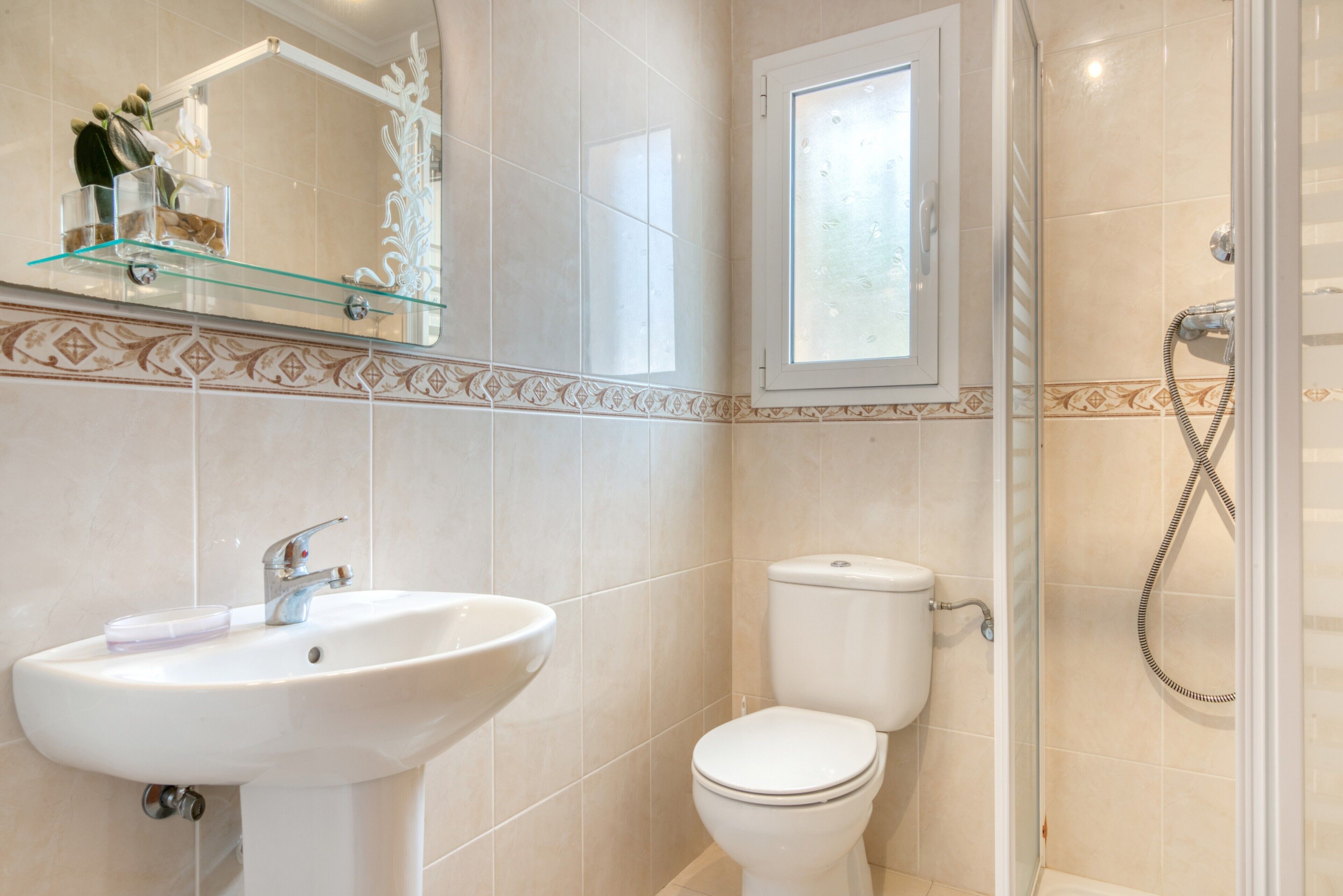 A bathroom with a sink, toilet, and shower.