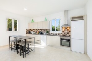 Una cocina moderna con una isla central, horno empotrado y lavavajillas.
