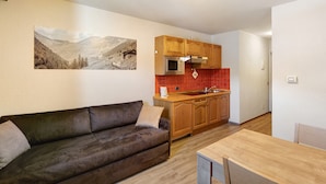 A modern kitchen with wooden cabinets, a microwave, and a red backsplash. - Holiday Apartment "Casa Marcos n 35" with Mountain View, Balcony & Wi-Fi (Livigno)