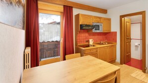 A compact kitchen with wooden cabinets, a microwave, and a small sink. - Holiday Apartment "Casa Marcos n 36" with Mountain View, Balcony & Wi-Fi (Livigno)
