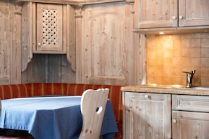 A wooden interior with a table and bench, a sink, and cabinets.