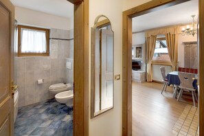 Une salle de bain comprenant des toilettes, un lavabo et un espace douche.