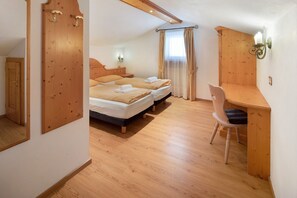 Une chambre à coucher comprenant un lit, deux tables de chevet, un bureau avec une chaise et un miroir.