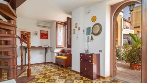 A staircase leading to a landing with a patterned floor, a wooden cabinet, and a potted plant. - Apartment 'Casa Florio' with Shared Terrace, Wi-Fi and Air Conditioning (Taormina)