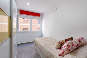 A bedroom with a bed, a window, and a red ceiling.
