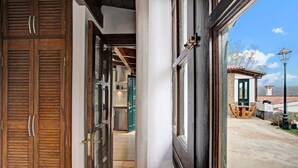 A hallway with wooden doors, a view of a dining area, and a stone wall. - Holiday Home "La Escalincha" with Mountain View, Shared Pool & Wi-Fi (Tegueste)