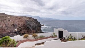 A coastal view with a white building, a black door, and a lamp post. - Holiday Home "Faro de Sardina Frente al Mar" with Sea View, Pool & Wi-Fi (Galdár)