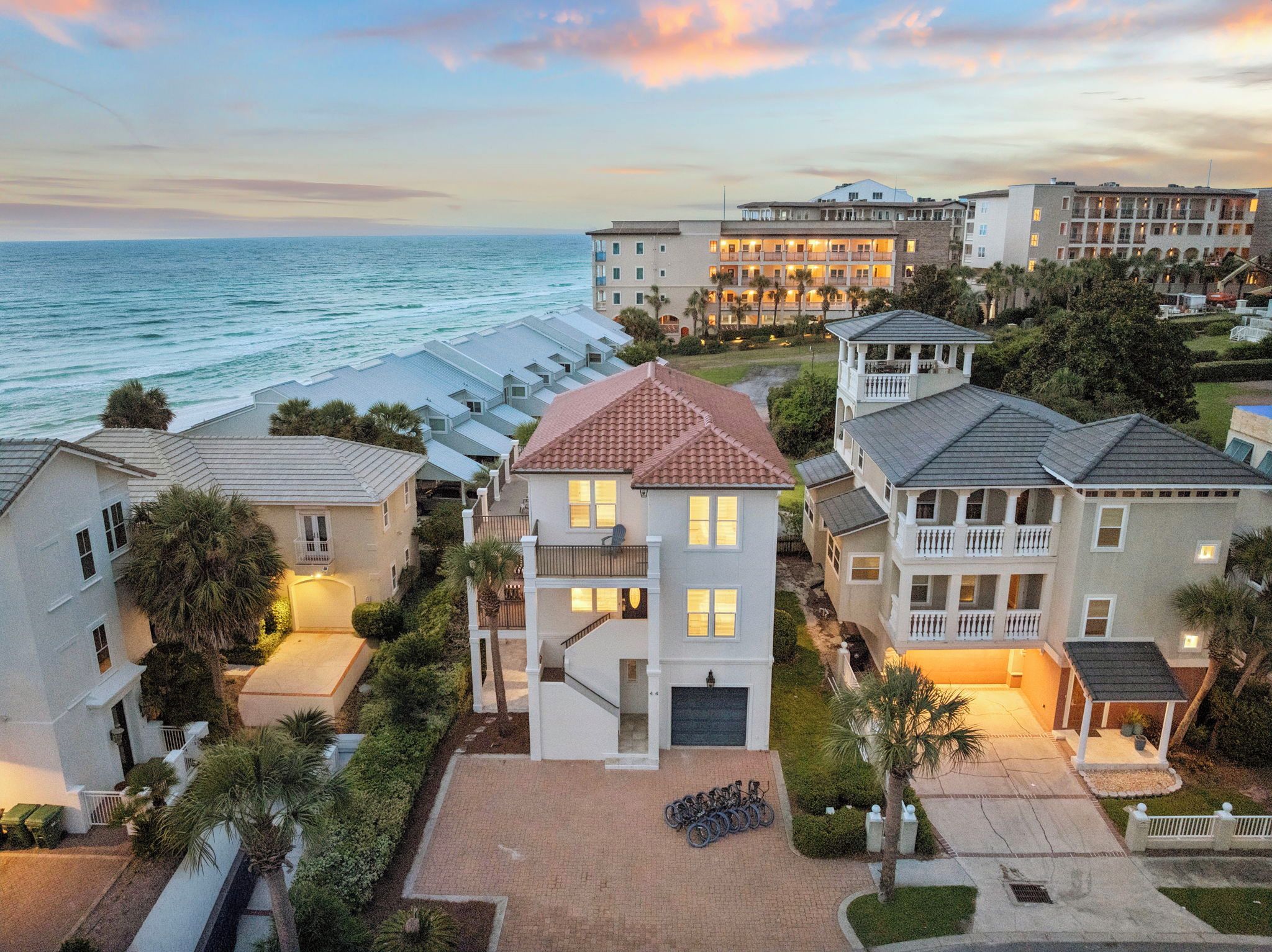 A coastal hotel with multiple buildings, a central tower, and a view of the sea.