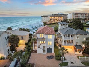 A coastal hotel with multiple buildings, a central tower, and a view of the sea.