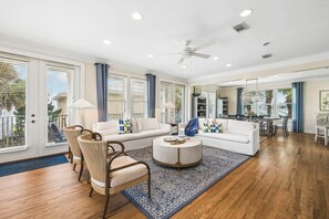 A spacious living room with a large sofa, a coffee table, and a dining area.