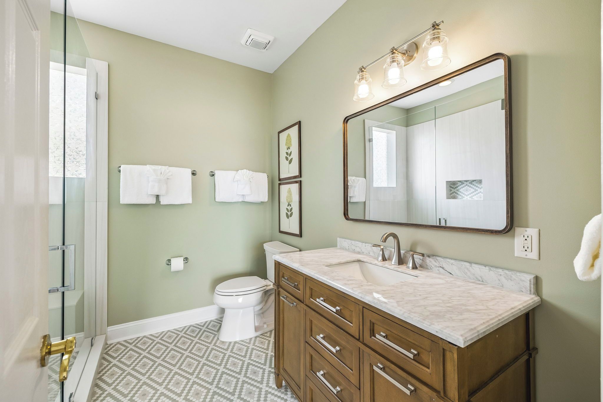 Une salle de bain comprenant des toilettes, un lavabo, un meuble-lavabo et un espace douche.