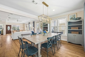 A spacious kitchen with a wooden dining table, modern chairs, and a pendant light fixture.