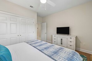 A bedroom with a bed, a television on a stand, a wardrobe, and a ceiling fan. - Gulf View Home | Steps to Beach Access (Santa Rosa Beach)