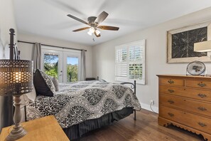 A bedroom with a bed, a ceiling fan, a dresser, and a window with shutters. - SAN GABRIEL RIVER Retreat WATERFRONT Panoramic View PRIVATE POOL Outdoor Living! (Georgetown)