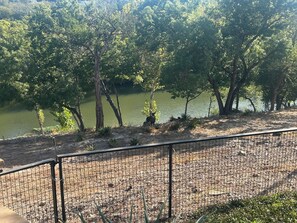 A fenced area with a view of a lake and trees. - SAN GABRIEL RIVER Retreat WATERFRONT Panoramic View PRIVATE POOL Outdoor Living! (Georgetown)