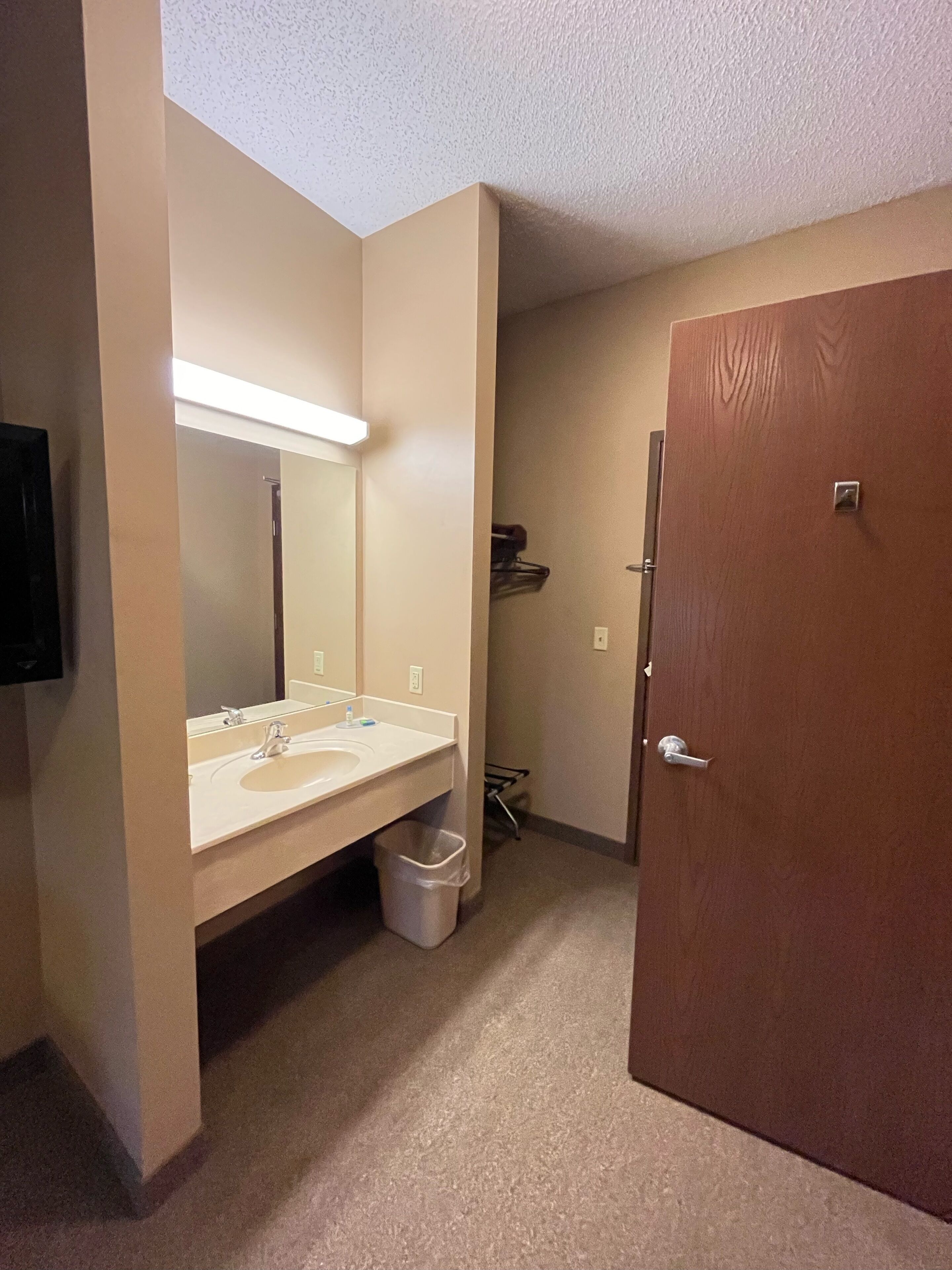 Un baño con lavamanos doble, espejo y una puerta.