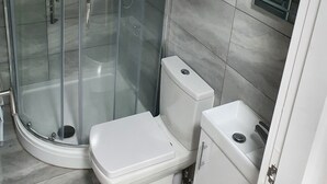 A modern bathroom with a glass-enclosed shower, a toilet, and a sink. - Immaculate 3-bed Studio in Liverpool City Centre (Liverpool)