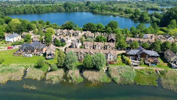 Vista aérea de una zona residencial con casas agrupadas alrededor de un lago, rodeado de vegetación.