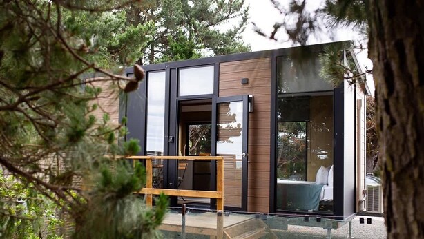A modern, compact building with large glass windows and a wooden exterior. - Pacific View by Tiny Away (Leithfield)