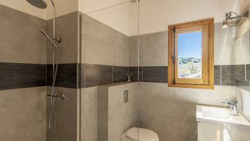 A modern bathroom with a shower, toilet, and sink.