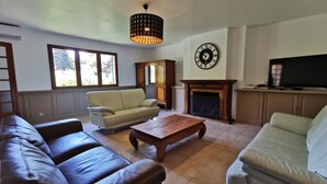Ein Wohnzimmer mit Kamin, einer großen Uhr und einem Fernseher.