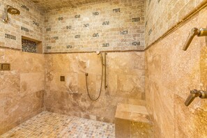 A bathroom with a tiled floor, a shower area, and a wall with a mosaic pattern. - Abbey Manor on Pinehurst #6- Golf Views -Sleeps 24 (Pinehurst)