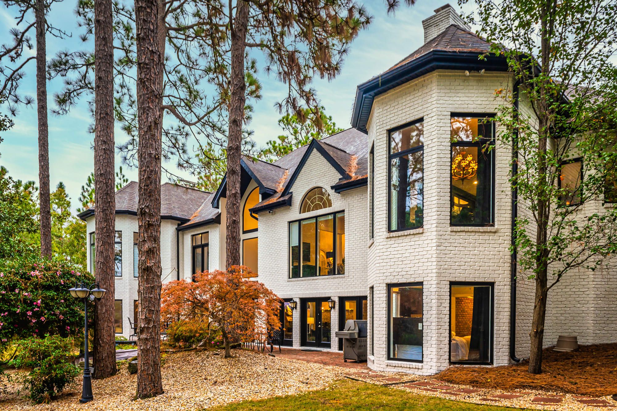 A multi-story house with large windows and a brick exterior.