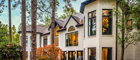 A multi-story house with large windows and a brick exterior.