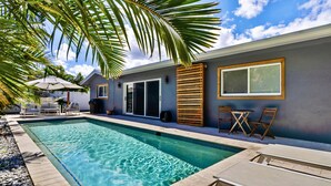 A swimming pool with lounge chairs and a covered seating area. - Beach Bliss: Heated Pool, BBQ & Tropical Vibes 🌊 (Oakland Park)
