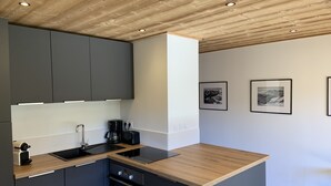 Eine moderne Küche mit dunklen Schränken, einer Holzarbeitsplatte und einem eingebauten Backofen.