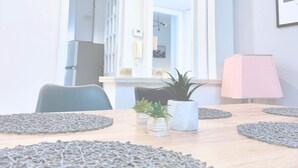 Un comedor con una mesa de madera, sillas y una planta en maceta.